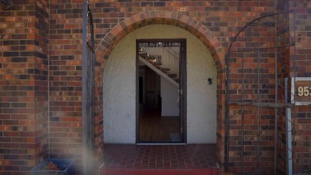 Arched brick doorway leading into a modern interior space, showcasing architectural design and home entryway.