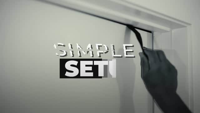 A person installing a "Simple Set" sign on a door, showcasing professional signage setup.