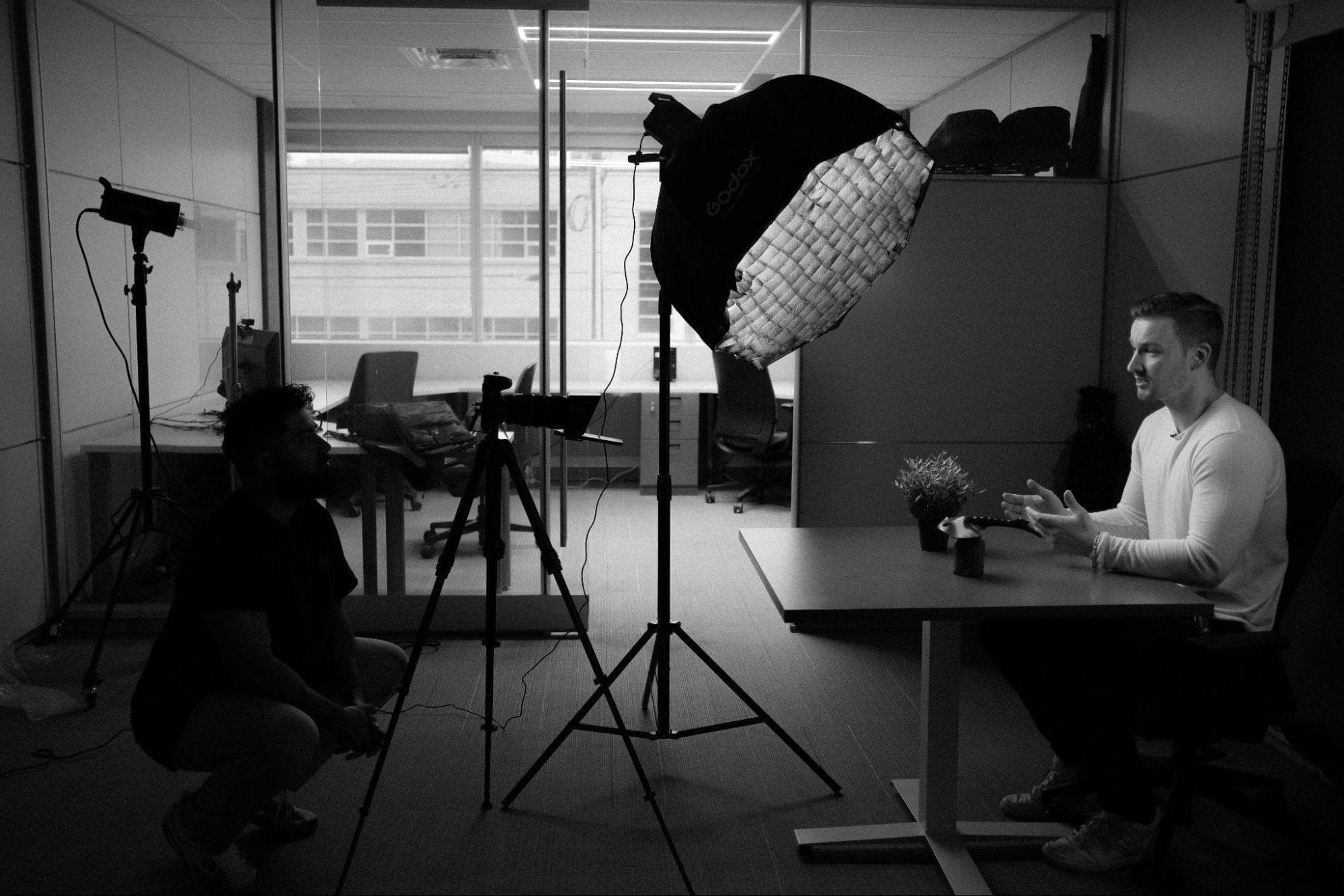 High-quality lighting setup for professional video recording in an office setting, with a businessman being interviewed for engaging content creation, focused on entrepreneurship and corporate communication.
