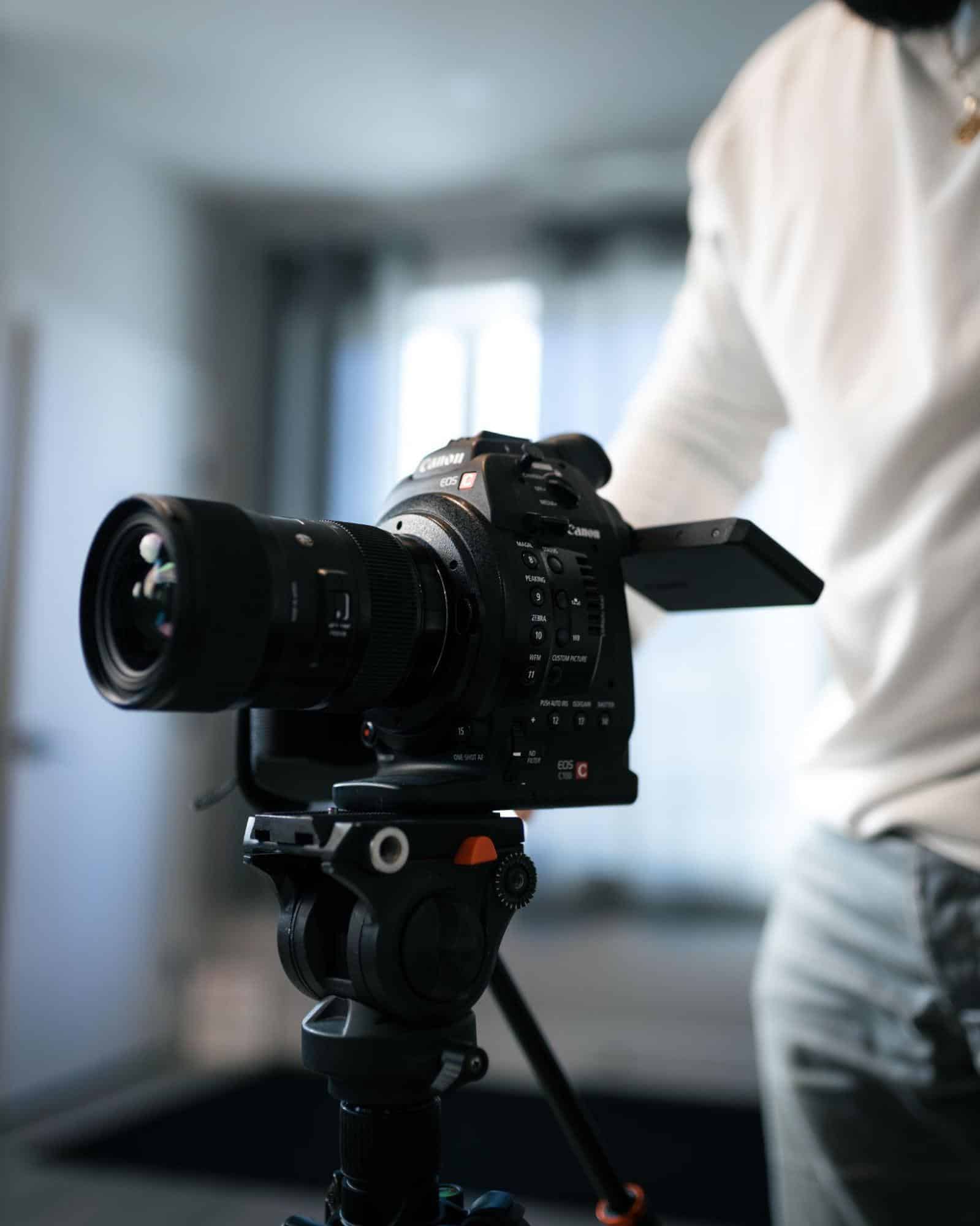 High-quality professional Canon cinema camera on tripod, used for film production and videography, showcasing advanced video recording technology and cinematic equipment.