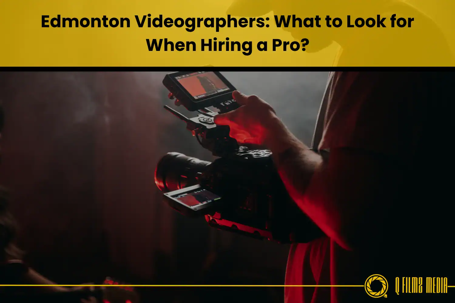 Professional videographer holding a camera and monitor in a dark studio setting for film and video production.
