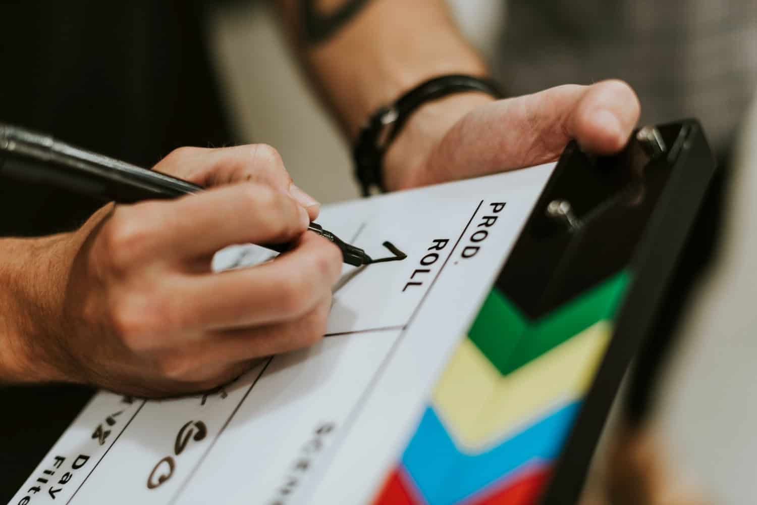 High-quality image of a film slate being marked for a movie production, emphasizing film industry, filmmaking process, and production planning. Perfect for promoting film projects or media production services.