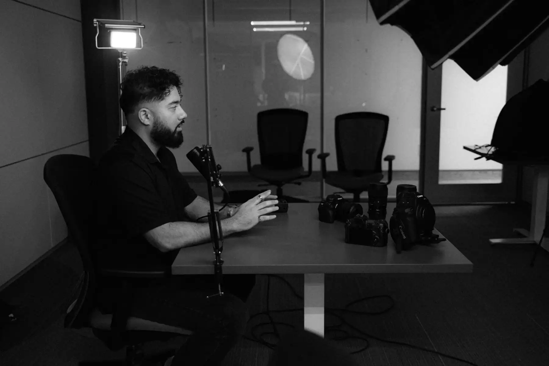 Professional videographer in a modern recording studio preparing for a video shoot, with cameras, lighting, and equipment set up for high-quality content creation.