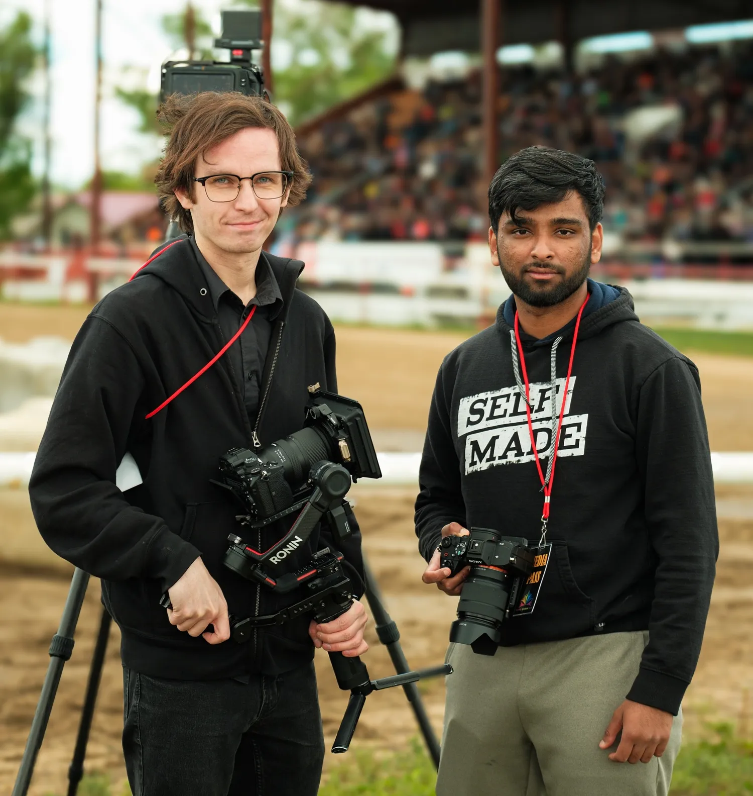 An image of two videographers with professional cameras at an outdoor event, showcasing event videography services in Edmonton for weddings, sports, or corporate events.