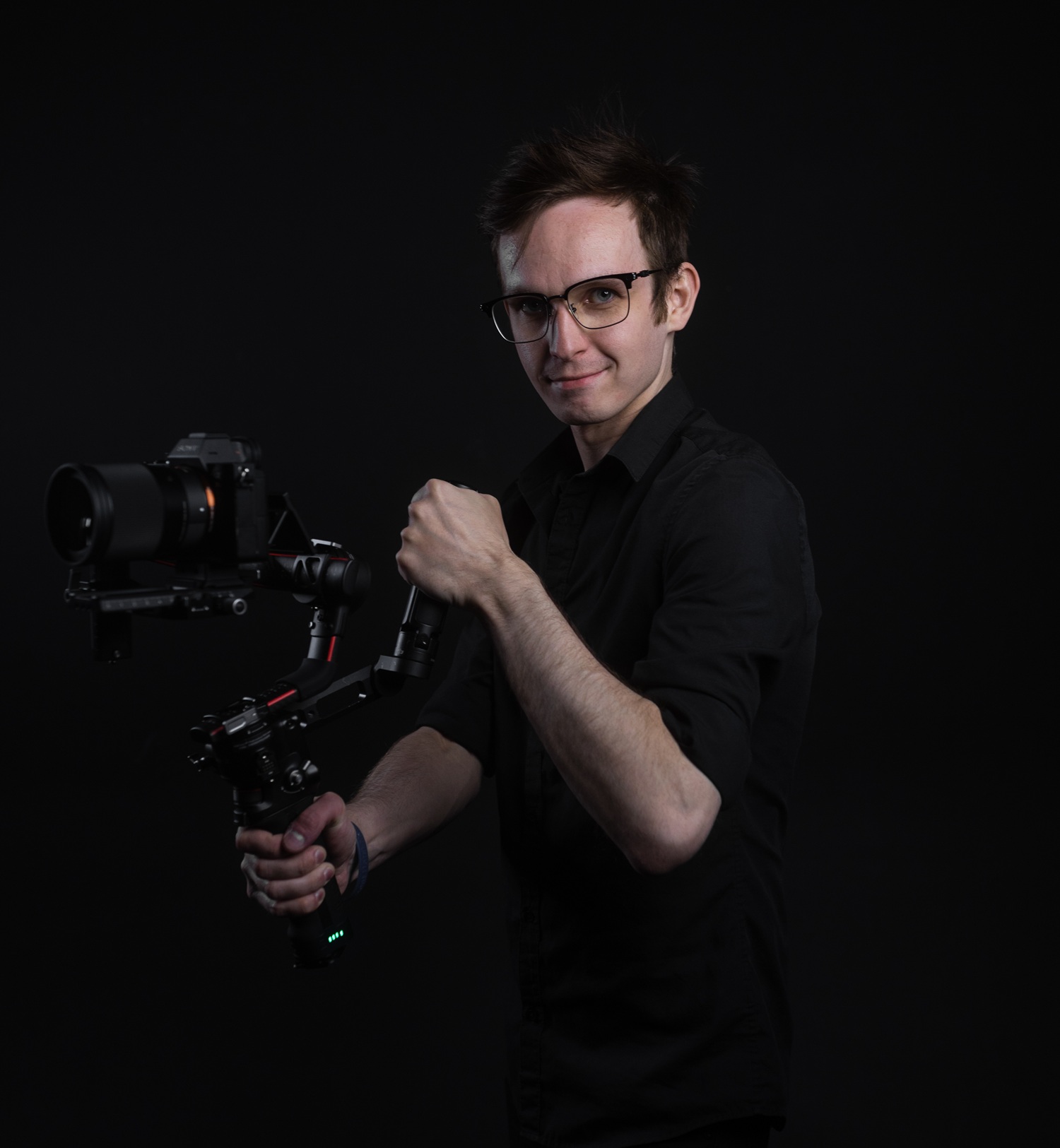 Young male videographer holding a professional camera rig, ready to shoot high-quality videos in Edmonton. Focused on capturing dynamic footage for media projects.