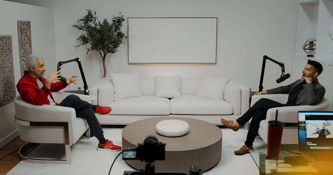 Two men recording a testimonial interview in a modern, well-lit studio with professional audio equipment and a white sofa.