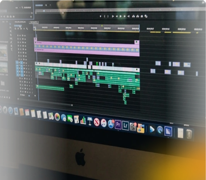 Close-up of a video editing timeline on a MacBook screen, showing multiple tracks and clips in a professional editing software.