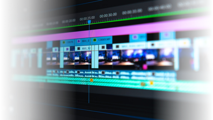 Close-up of a professional video editing timeline with colorful tracks and clips, representing video production work at Q Filmz Media.