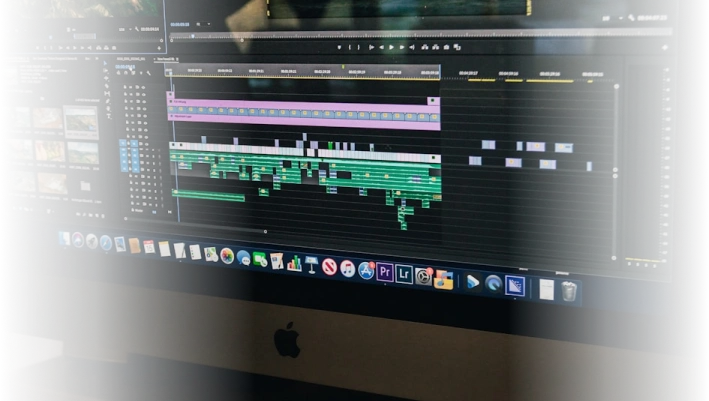 Computer screen displaying video editing software with multiple tracks and clips, representing professional video production at Q Filmz Media.
