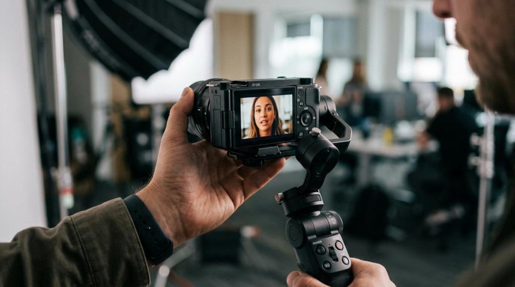 Close-up of a person holding a professional camera recording a woman in a studio setting for corporate video content.