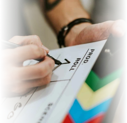 Person writing on a clapperboard labeled 'PROD ROLL' during film production planning for SEO.