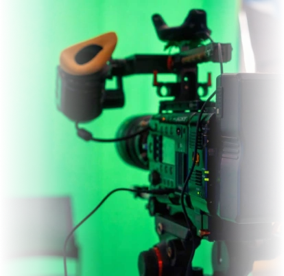 High-quality professional video camera with accessories on a green screen background, used for film production and media creation.