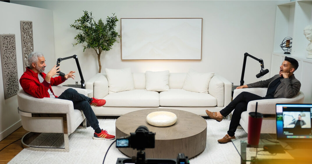 Two men recording a podcast interview in a contemporary studio with professional microphones and recording equipment.